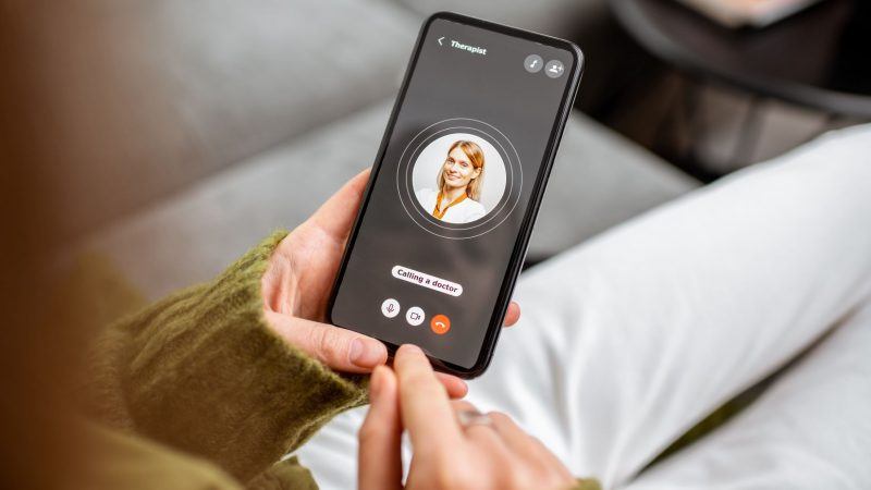 Lady using phone which shows a call being made to a doctor